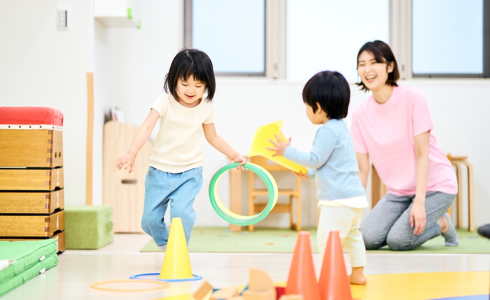室内で遊びながら運動に取り組む子どもたちとスタッフ