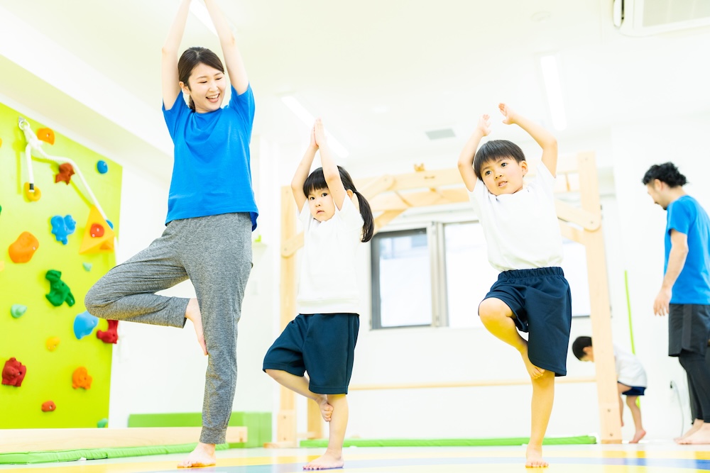 室内で身体を動かしながらバランス遊びに取り組む子どもたち